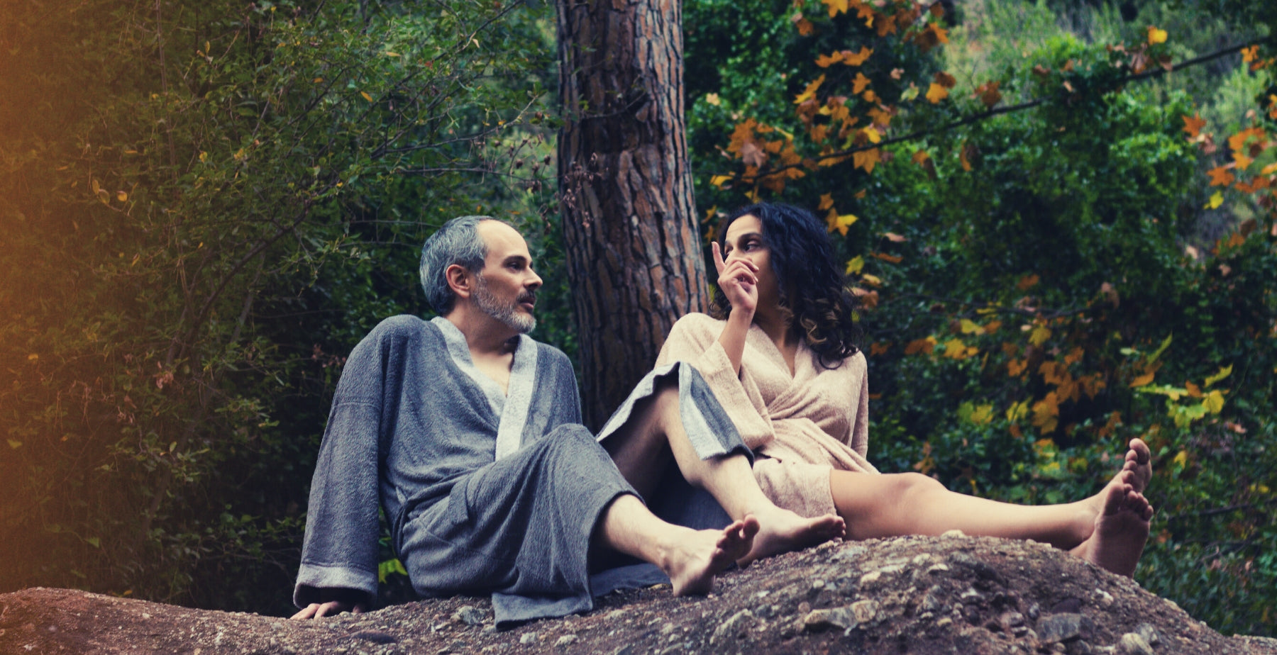 Dos personas charlando en el bosque con los albornoces Onsen y Sento